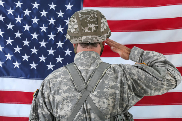 Saluting soldier with national flag of USA on background, back view - Photo, Image