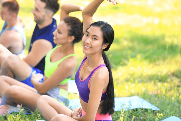 Group of young sporty people training together outdoors - 写真・画像