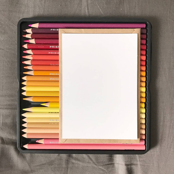 Blanco ansichtkaart met envelop en gekleurde potloden - Foto, afbeelding