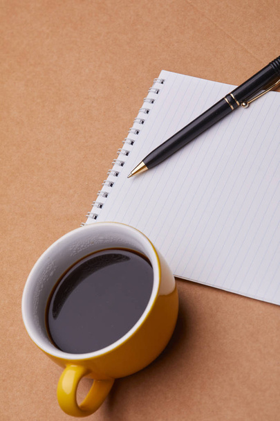 блокнот з чашкою кави і ручкою на столі, бізнес-концепція
 - Фото, зображення