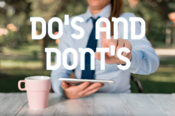 Do S と Dont S. 概念的な写真のルールや習慣を示すテキスト記号 何らかの活動や行動に関する女性ビジネスパーソンがテーブルのそばに座って携帯電話を保持. - 写真・画像