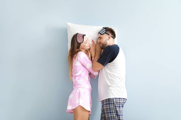 Jeune couple avec oreiller sur fond de couleur
 - Photo, image