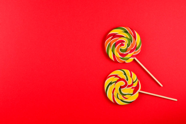 Colorful candy on a red  background. Lollipop. Top view. Copy sp - Photo, Image