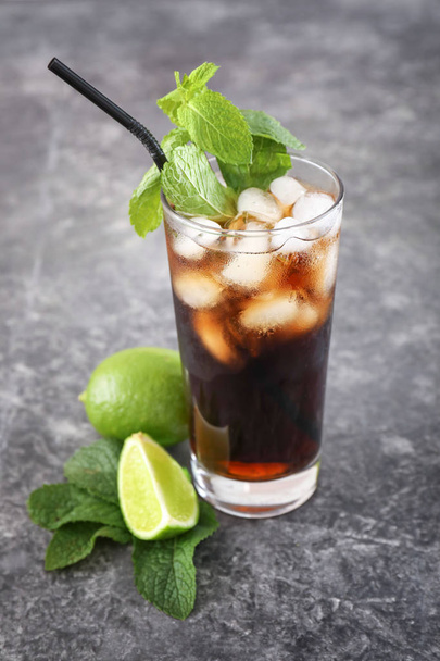 Glass of cold cola and lime on grey table - Foto, Imagem