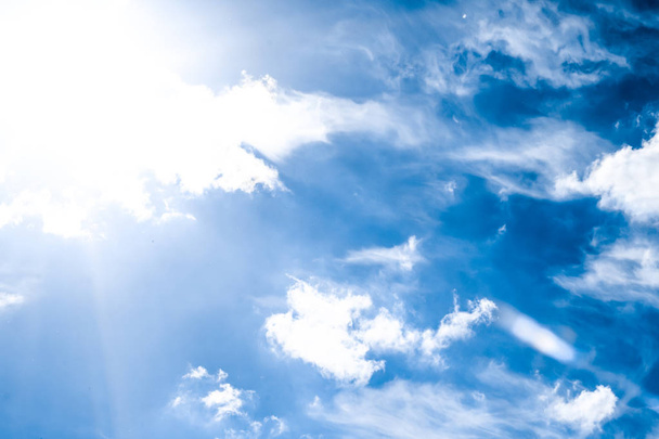 Modrá obloha pozadí, bílé mraky a jasné sluneční světlo - Fotografie, Obrázek