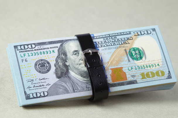 empilhar dólares envolto com cinto, close-up
 - Foto, Imagem