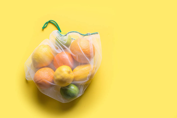 Fruits in reusable eco-friendly mesh bags on yellow. Zero waste. Ecological concept. Stop pollution. - Φωτογραφία, εικόνα
