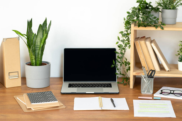 Supplies and equipment for business or educational purposes on wooden desk by the wall in office or at home - Foto, Imagen