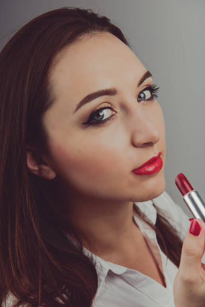 Red lipstick held in female hand, copyspace - Foto, imagen
