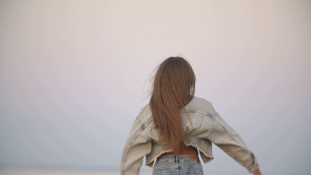 meisje in jeans kleren op een achtergrond van de zee - Video