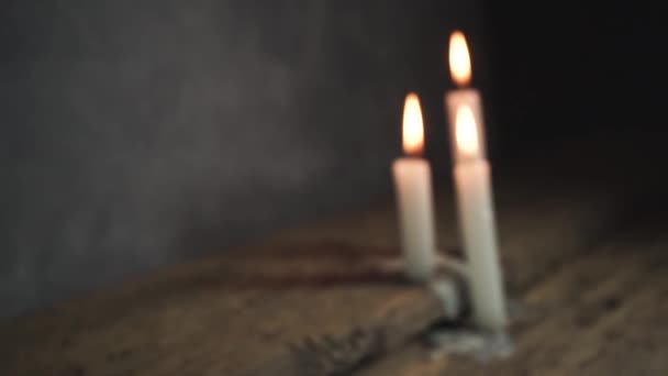 close up schöne brennende Kerzen auf einem alten Eichentisch und dunkelgrauen Wandhintergrund.  - Filmmaterial, Video