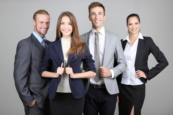 Business team standing in row on grey background - Foto, afbeelding