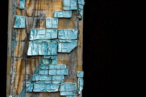Part of old wooden boards painted in light blue cracked paint with several layers of shelled paint pieces - Photo, Image