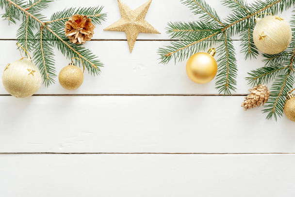 Kerst samenstelling. Kerstversiering, Fir Tree takken, gouden ornamenten op houten witte rustieke achtergrond. Platte lay, Top uitzicht. Kopieer ruimte. Banner mockup. - Foto, afbeelding