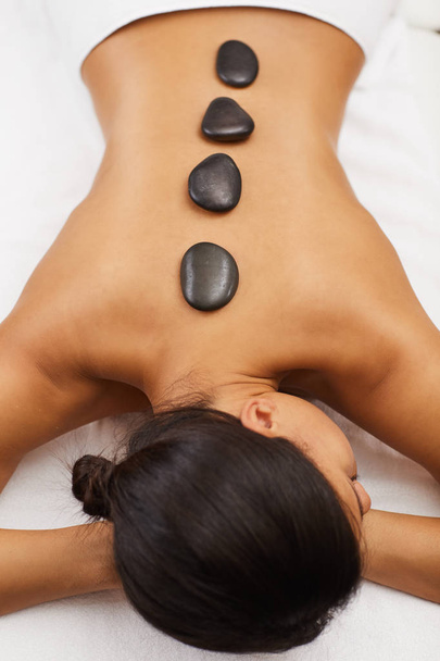 Acima vista retrato de mulher bronzeada deitada na mesa de massagem durante a terapia de pedra em SPA, espaço de cópia
 - Foto, Imagem