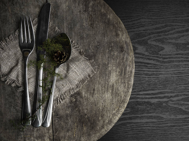 μαχαιροπίρουνα μαχαίρι, πιρούνι, πράσινο κουτάλι κλαδί σε ένα παλιό ξύλινο τραπέζι, τονισμένο top θέα, επίπεδη θέση, αντίγραφο χώρου - Φωτογραφία, εικόνα