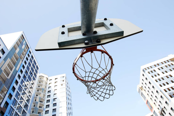 Low angle view of basketball hoop in urban background, copy space - Photo, Image