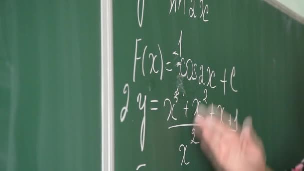 Estudiante cerca de una pizarra escolar con fórmulas matemáticas
 - Metraje, vídeo