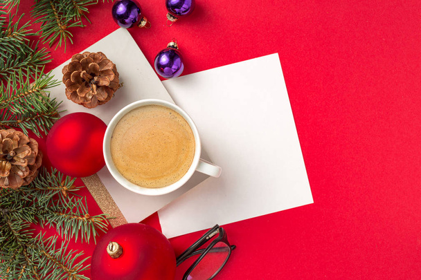 Christmas decorations with notepad, pen, glasses and cup coffee on red workspace top view - Fotografie, Obrázek