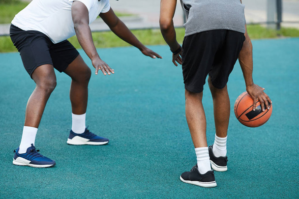 Back view low angle of two African-American guys playing basketball outdoors, copy space - Photo, Image