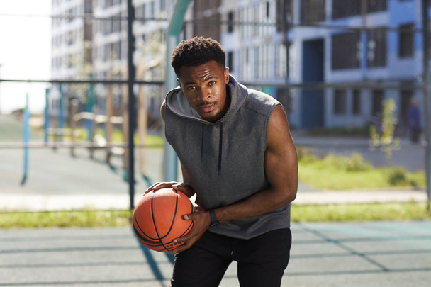 Портрет визначеного баскетболіста, який поспішає на камеру, тримає м'яч, копіює простір
 - Фото, зображення