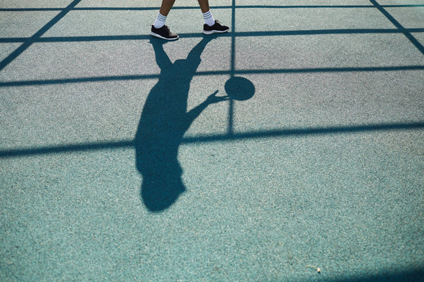 Silhouette dell'uomo irriconoscibile che gioca a basket in campo all'aperto, sfondo sportivo, spazio per la copia
 - Foto, immagini