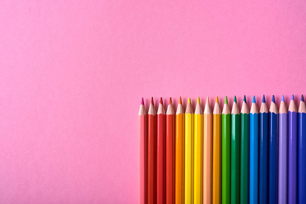 Color pencils on pink pastel background, close up. Set of colorf - 写真・画像