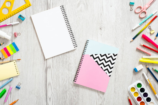 Back to school concept, creative layout with with various school supplies and paper notepads on wooden background. Flat lay style composition, top view, overhead. - Photo, Image