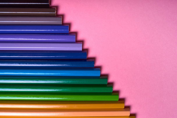 Color pencils on pink pastel background, close up. Set of colorf - Zdjęcie, obraz