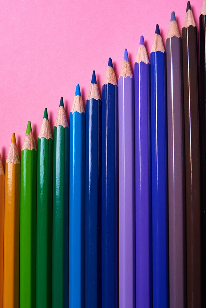 Color pencils on pink pastel background, close up. Set of colorf - Photo, image