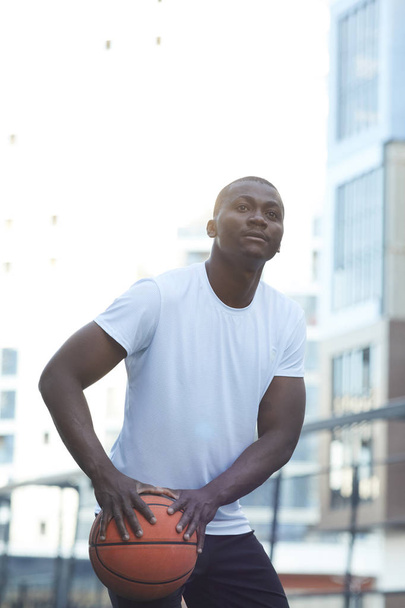 Portret muskularny afrykański człowiek grający w koszykówkę w otoczeniu miejskim - Zdjęcie, obraz