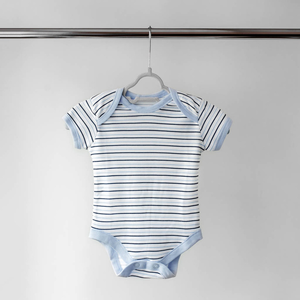 Kinderbody für ein Baby in einem Streifen. das Konzept der Kleidung, Mutterschaft und Neugeborenes. - Foto, Bild