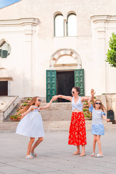 Adorable little girls and young mother have fun in italian old village - Photo, Image