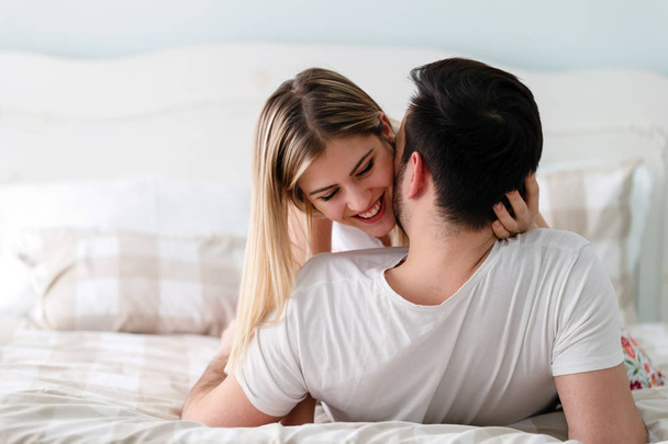 Young happy couple having romantic time in bedroom - Zdjęcie, obraz