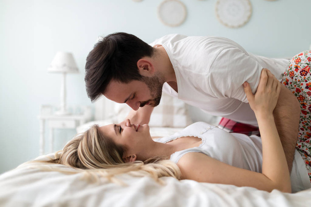 Young happy couple having romantic time in bedroom - Photo, image