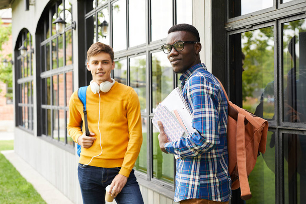Portrait of African-American student with friend posing outdoors in college campus and looking at camera, copy space - Foto, imagen