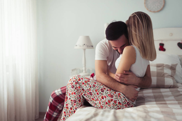 Young happy couple having romantic time in bedroom - Photo, Image