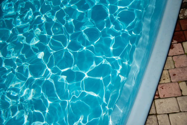 Sonnenlicht reflektiert auf blauer Wasseroberfläche im Schwimmbad - Foto, Bild