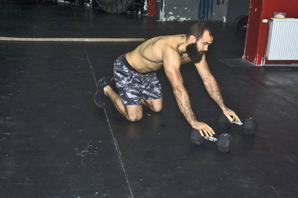 Homem muscular fazendo exercícios com halters Dumbbell
 - Foto, Imagem