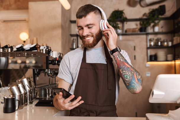 Smiling attractive man barista standing - Valokuva, kuva