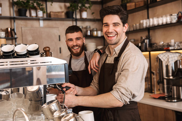 Group of cheerful men baristas wearing aprons - Photo, Image