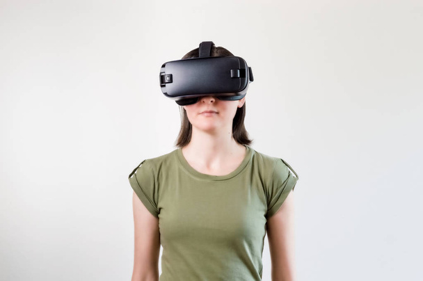 Brunette woman exploring modern technology virtual reality with head mounted display on white background - Photo, Image