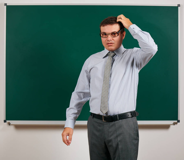 Portret van een leraar met ouderwetse brillen poseren op Blackboard background-terug naar school en onderwijsconcept - Foto, afbeelding