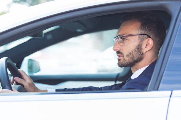 Bearded man holding steering wheel while driving car - Photo, image