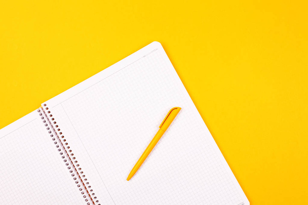 PLAN 2020. Cuaderno blanco sobre fondo amarillo, bolígrafo amarillo, goles para el año
. - Foto, imagen