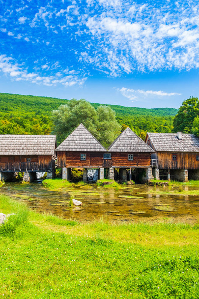 Croácia, região de Lika, fonte do rio Majerovo vrilo de Gacka, aldeia tradicional, moinhos de madeira velhos e casas de campo
 - Foto, Imagem