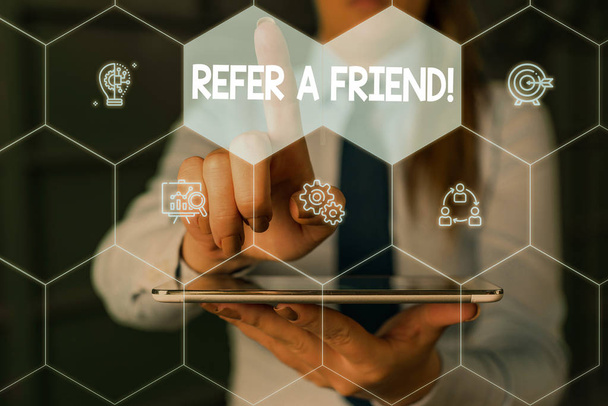 Writing note showing Refer A Friend. Business photo showcasing direct someone to another or send him something like gift Woman wear formal work suit presenting presentation using smart device. - Photo, Image