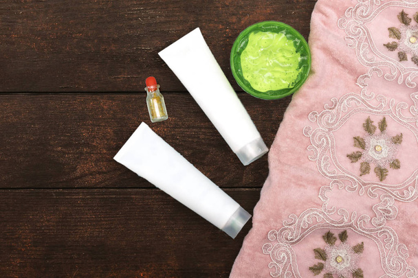 Aloë Vera Gel en Tube Cream, sandarac fles en roze schone handdoek, zelfgemaakte Beauty concept - Foto, afbeelding