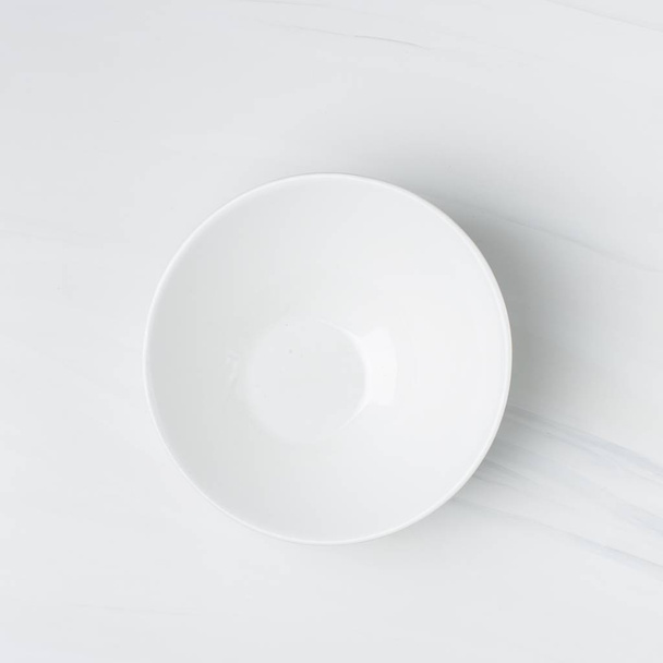 Closeup shot of an empty white ceramic bowl on a white background - Foto, immagini