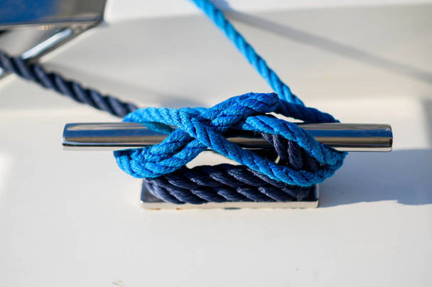 Mooring rope. Blue mooring rope tied around steel anchor on boat or ship - Valokuva, kuva